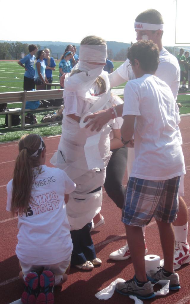 Juniors almost covering their teacher from head-to-toe with toiler paper