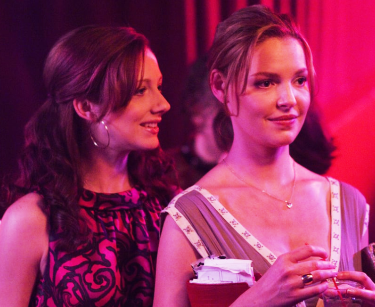 Judy Greer (left) serves as the literal and figurative sidekick to Katherine Heigl (right) in 27 Dresses, a movie in which Katherine Heigl suffers as the side character in other peoples love stories. 