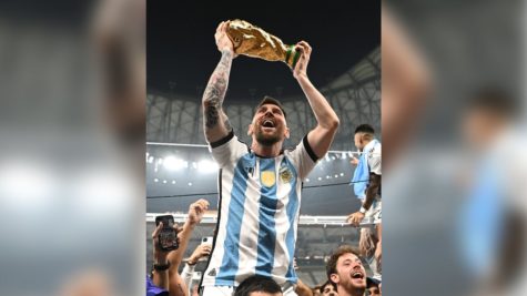 Lionel Messi holds the World Cup trophy. (Credit: Photographer Shaun Botterill, CNN.com)